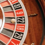 Рулеточное колесо в казино с игроками за столом